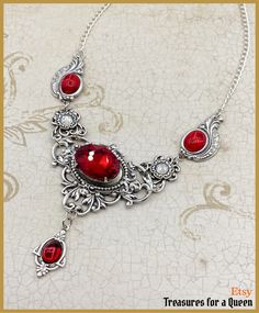 A Victorian Gothic Ruby Red Crystal Edwardian Antique Vintage Inspired Necklace with Silver Plated brass Filigrees and Swarovski Crystal Rhinestones: This item will be made just for you and may take 3 to 5 days to ship Inspired by the lush extravagance of Victorian Era jewelry combined with fantastical Gothic flair, this necklace isn't for the faint of heart.  This necklace is made using several different vintage inspired filigrees all of which are Silver Plated brass which I have polished and given a coat of Renaissance Wax. The center stone is an 18x13mm oval crystal in a beautiful cherry red color. On each side of the center piece are matching cherry red 10x8mm cabochons and dangling from the center is another smaller (8x6mm) matching red cabochon. Throughout the necklace are clear Swar Victorian Necklace For Formal Valentine's Events, Red Gothic Metal Necklace, Red Gothic Necklace For Formal Occasions, Ornate Pendant Jewelry For Valentine's Day, Elegant Necklaces With Intricate Design For Valentine's Day, Gothic Jewelry For Valentine's Day Formal, Ornate Necklace For Valentine's Day Gift, Red Metal Filigree Jewelry, Ornate Red Pendant Jewelry