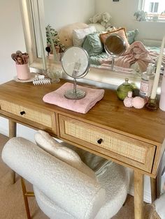 a vanity with a mirror, stool and other items on it in front of a couch