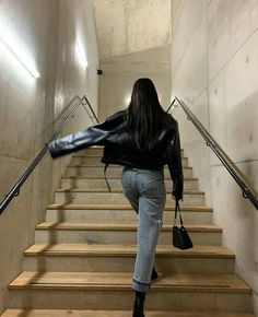 a woman walking up some stairs with her handbag