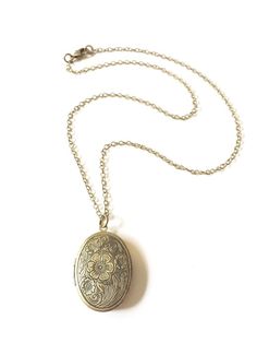 >>> Keep their memory close when you wear this beautiful remembrance locket.>>> Whether for yourself or someone else, every order is creatively packaged and ready to gift.>>> An antiqued brass photo locket with floral detail hangs from an antiqued brass chain; lobster clasp closure.>>> Locket pendant measures 27mm x 33mm {larger than a quarter} and is lead and nickel safe.>>> Back of locket is smooth but distressed giving it a vintage appearance.>& Classic Locket Necklace With Adjustable Chain As Gift, Heirloom Style Bronze Necklace As Gift, Heirloom Bronze Necklace Perfect For Gifts, Heirloom Bronze Necklace For Gift, Nickel-free Oval Wedding Necklace, Nickel-free Oval Necklace For Wedding, Nickel Free Oval Necklace For Wedding, Classic Nickel-free Locket Necklace As Gift, Classic Nickel-free Locket Necklace Gift