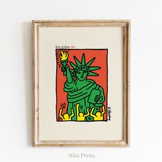 a framed painting of the statue of liberty holding a torch in her hand, on a white wall