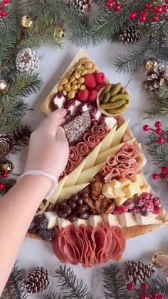 a person reaching for a piece of food on top of a table covered in pine cones