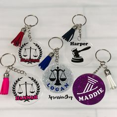 six keychains with different designs on them, including one that has a judge's hammer