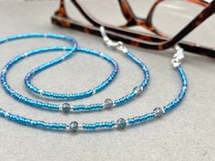 Dainty and bohemian eyeglass necklace chain in blue/Turquoise tones, made with Preciosa Czech crystal seed beads tiny silver plated crystal seed beads and delicate light blue cubic zirconia crystal beads. Paired with grey blue cubic zirconia crystal beads, this handmade eyeglass chain will definitely create a unique look.  The eyeglass lanyard is made on strong quality beading wire with silver plated wire guardians that protect the quality eyeglass holder grips. The necklace is ended with spring Beaded Eyeglass Chain, Glasses Cord, Sunglasses Necklace, Crystal Sunglasses, Eyeglass Necklace, Eyeglass Holder, Eyeglass Chain, Grandma Gift, Glasses Chain