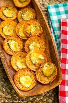 small appetizers are arranged on a wooden platter with red and white checkered napkins