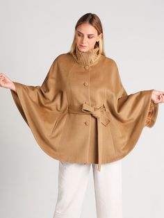 So soft - you'll want to keep it on all day. Our Clara cape is the definition of timeless. With its classic belted cape silhouette, it will never go out of style. Expertly crafted in baby alpaca and wool for an exquisite finish that will stand the test of time. A wonderful gift idea for yourself or someone special. Product Details: Belted Cape with Rib-knit Collar 70% Baby Alpaca / 30% Wool High Neckline Lined, with Pockets Below Hip Length Fastens with 4 buttons (+1 Spare). Press Studs at Sides Knitted Ponchos, Belted Cape, Corporate Wear, Suri Alpaca, Knitted Cape, Capes For Women, Designer Dresses Indian, Knitted Poncho, Baby Alpaca