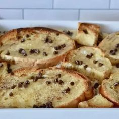 a white dish filled with slices of bread covered in chocolate chips