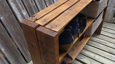 a wooden bench with baskets on top of it and shoes in the bottom shelf next to it