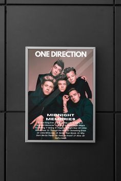 the one direction poster hanging on a wall in front of a black tile background with an advertise