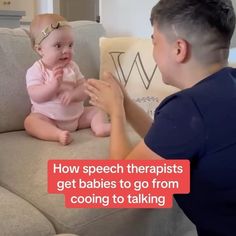 a man sitting on top of a couch next to a baby in a pink dress