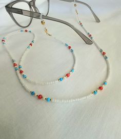 Sunglasses chain Eyeglasses chain Glasses holder This beautiful chain for glasses is made of small white and gold glass beads 2 mm in combination with coral and turquoise beads 3-4 mm. The chain can also be worn as a mask holder if you remove the silicone rubber for the glasses. At the end of the chain is a gold brass clasp in 24 k gold color. If you buy this chain it comes in a beautiful velvet gift bag. We send all shipments by registered mail with a security tracking code. Thank you so much for visiting! FREE SHIPPING! Glasses Necklace Holder, White Festival Necklaces With Lobster Clasp, White Necklace With Lobster Clasp For Festivals, White Delicate Chain Necklace For Beach, Adjustable Delicate Chain Glass Necklace, White Beaded Necklaces With Adjustable Chain, White Jewelry With Adjustable Glass Chain, White Jewelry With Adjustable Chain For Summer, Trendy White Beaded Necklaces With Adjustable Chain