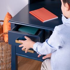 a little boy playing with a toy drawer