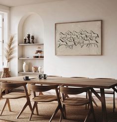 a dining room table and chairs in front of a large window with open shelves on the wall