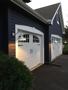 two white garage doors are open in front of a blue house