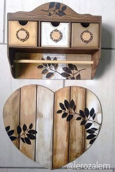 a wooden shelf with two heart shaped drawers and a mirror hanging on it's side