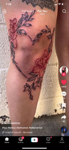 a woman's thigh with flowers and leaves tattooed on her leg, in the shape of a heart