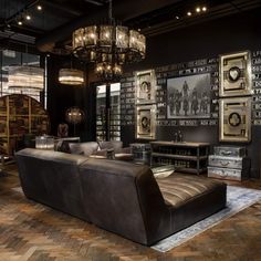 a living room filled with lots of furniture next to a wall covered in framed pictures