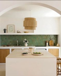 a kitchen with an archway leading to the dining room