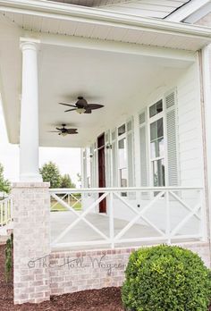 a white house with a porch and ceiling fan