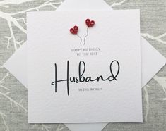 a card with two hearts on it and the words husband in the world written below