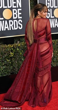 the back of a woman's dress with sheer red mesh on it and long sleeves