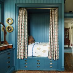 a bedroom with blue painted walls and curtains