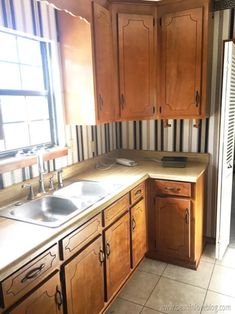 a kitchen with wooden cabinets and tile flooring