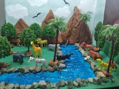 a group of animals that are standing in the grass next to some rocks and water