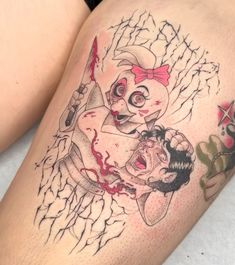 a woman's thigh with tattoos on her legs and an image of a clown