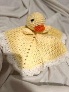 a crocheted ducky blanket on top of a bed