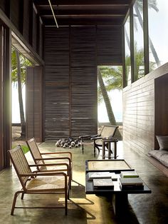 a living room filled with lots of furniture next to a wall covered in wooden slats