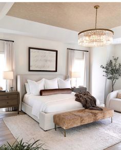 a large white bed sitting in a bedroom next to a window