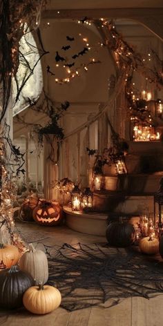 pumpkins and candles are on the floor in front of a staircase decorated for halloween