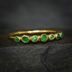 a gold ring with green stones on it