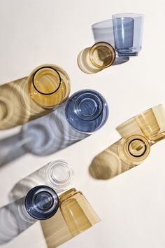 three shot glasses are sitting next to each other on a white surface with shadows coming from them