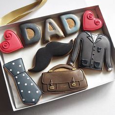 decorated cookies in the shape of men's clothing and accessories are displayed on a tray