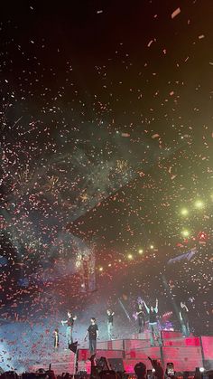 people are standing on stage with confetti in the air