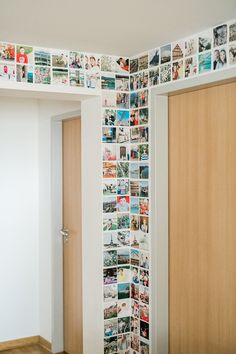 a room that has pictures on the wall and wooden doors in front of it,