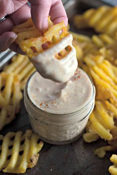 a person dipping some food into a jar