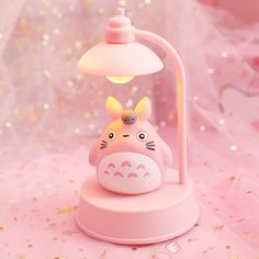 a pink lamp with a totoro figure on it's base and a white light