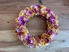 a wreath made out of flowers on top of a wooden table