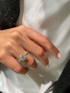 a woman's hand with a diamond ring on it