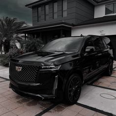 a black suv parked in front of a house