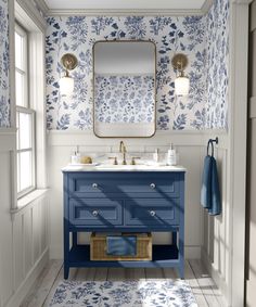 a blue and white bathroom with floral wallpaper on the walls, two sinks and a mirror