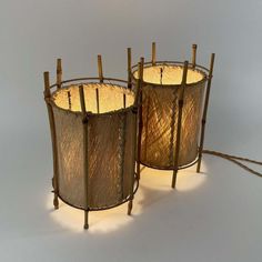 two lamps made out of bamboo sticks with lights on each side and one light in the middle