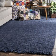 a living room with a blue rug on the floor next to a couch and coffee table