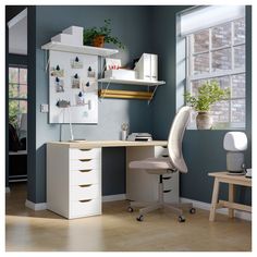 a desk with a laptop computer on top of it next to a chair and table