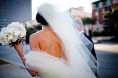 a bride and groom walking down the street