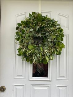 a wreath hanging on the front door of a house