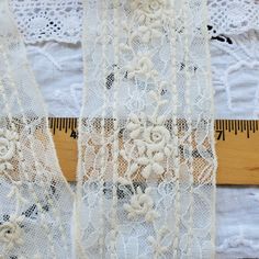 white lace with flowers on it next to a ruler